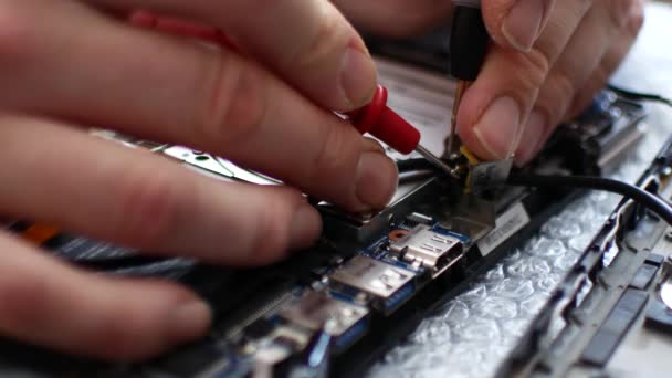 Engineer soldeert de voedingsconnector op een laptop. Close-up van laptop reparatie — Stockvideo
