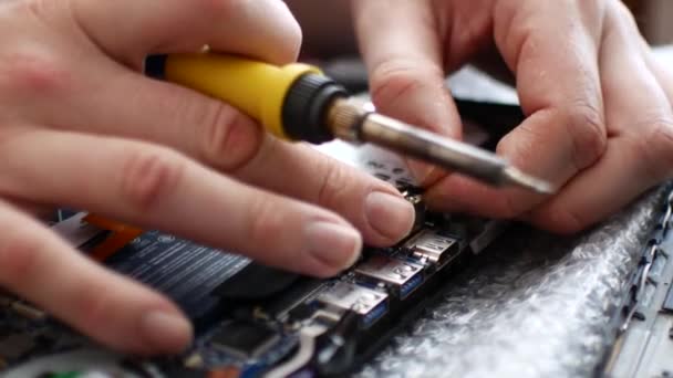 Engenheiro solda o conector de energia em um laptop. Close-up de reparação laptop — Vídeo de Stock