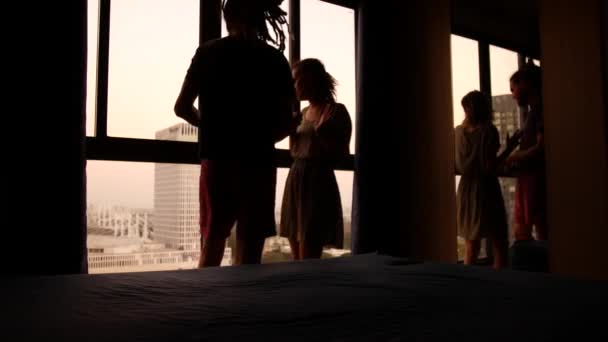 Marido e mulher estão brigando. Silhuetas no fundo de uma grande janela em um piso alto — Vídeo de Stock