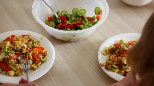Семейный ужин. Семья ест жареный рис и салат — стоковое видео