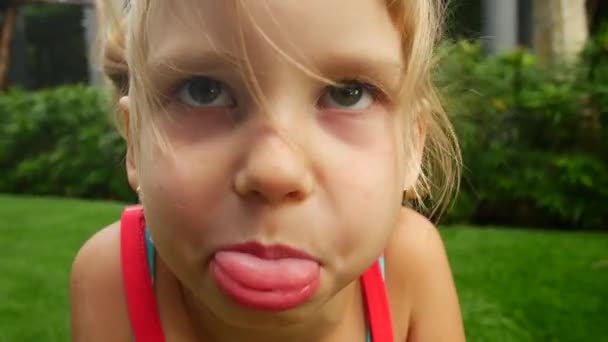 Portret van een kind. Meisje trekt gezichten en maakt grimaces — Stockvideo