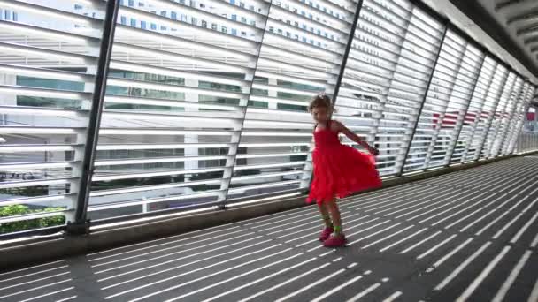 Dívka dítě v šatech víří na slunci přes žaluzie — Stock video