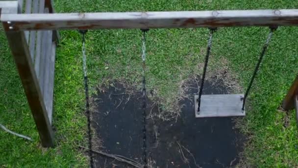 Chica en un columpio en un parque infantil — Vídeo de stock