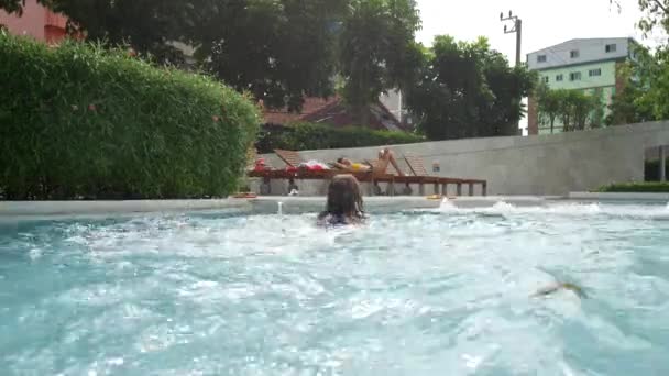A gyerek bemászik a medencébe.. — Stock videók