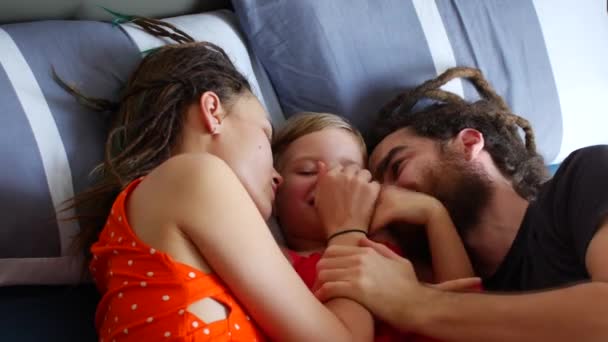 Família feliz descansando na cama. Mãe pai e filha rir e conversar — Vídeo de Stock