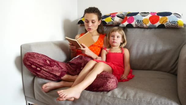 Mamma läser en bok för sin dotter — Stockvideo