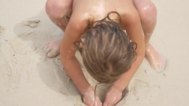 Egy gyerek játszik a homokban, tengerparti vakáció — Stock videók