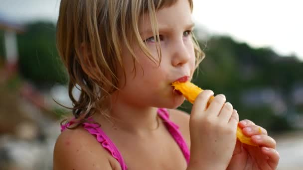 Portret van een meisje dat mango eet. — Stockvideo