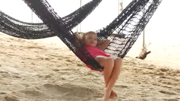 Barnflicka i hängmatta på stranden — Stockvideo