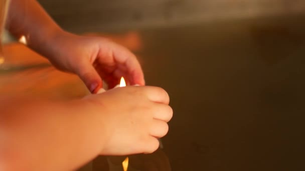 A gyerek kívánság-gyertyát gyújt egy buddhista templomban. — Stock videók