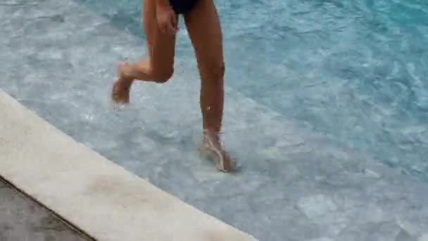 Dítě běží podél okraje bazénu — Stock video
