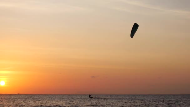 Puesta de sol en el océano, kite surfers paseo en el mar — Vídeo de stock