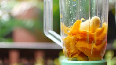 Throw fruit into a smoothie blender container