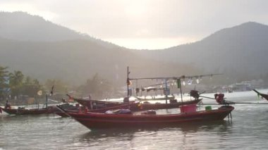 Sıcak bir körfezde dalgalar üzerinde sallanan balıkçı teknesi
