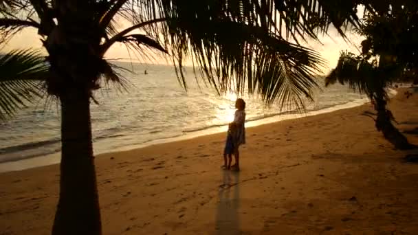 Matka i córka spacerują wzdłuż brzegu o zachodzie słońca — Wideo stockowe