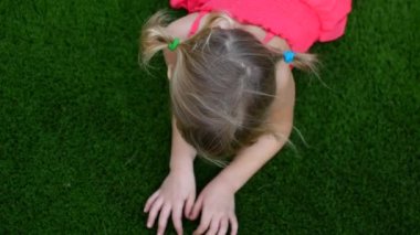 Çimlerin üzerinde çocuk kız, eller çimlerin üzerinde