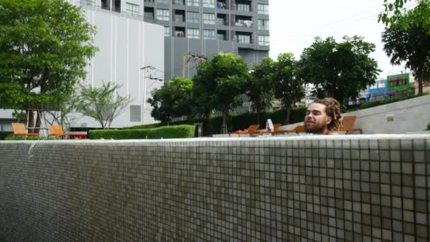 Verführerischer Mann schwimmt zum Beckenrand. — Stockvideo