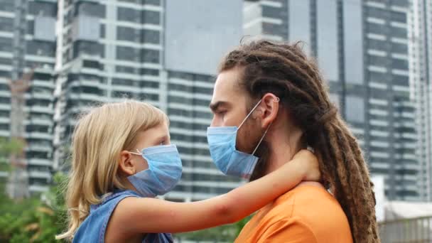 Kollarında kızı olan bir adam, ailesi kendisini koronavirüs 2019-ncov 'dan korur. — Stok video