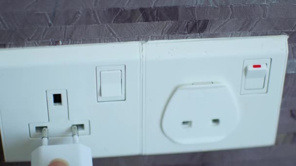 Connecting the charger to a foreign outlet through an adapter — Stock Video