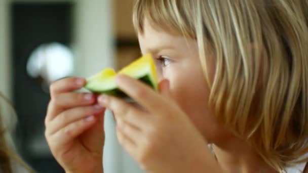 Παιδί κορίτσι τρώει κίτρινο καρπούζι — Αρχείο Βίντεο