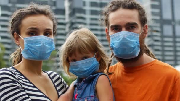 Familia en máscaras médicas protectoras contra el fondo de la metrópoli, epidemia de coronavirus 2019-nCoV — Vídeo de stock