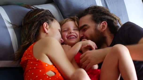 Família feliz descansando na cama. Mãe pai e filha rir e conversar — Vídeo de Stock