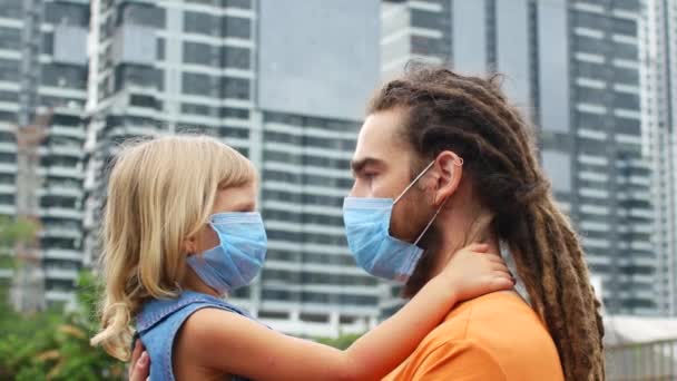 Człowiek z córką w ramionach, rodzina broni się przed koronawirusem 2019-ncov — Wideo stockowe