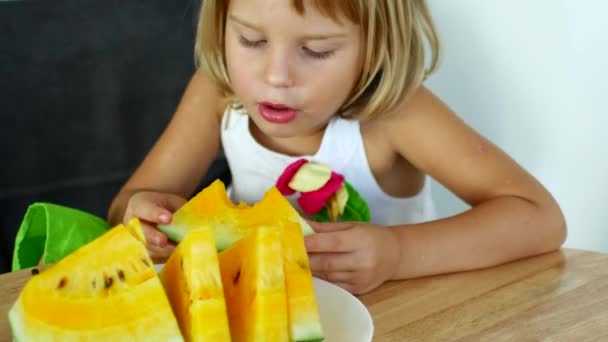 Child girl eats yellow watermelon — Stock Video