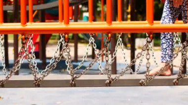 A girl walks over obstacles in the playground.