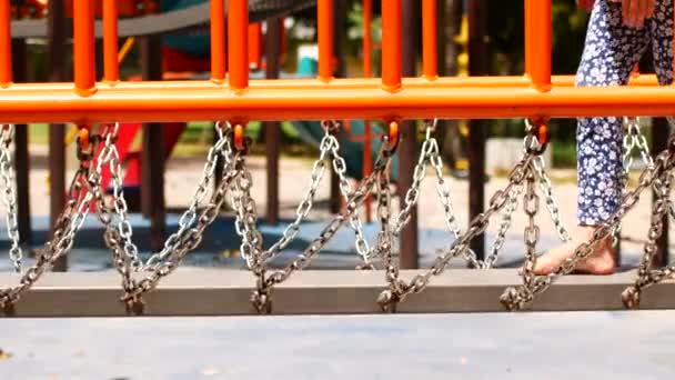 Uma menina caminha sobre obstáculos no playground . — Vídeo de Stock