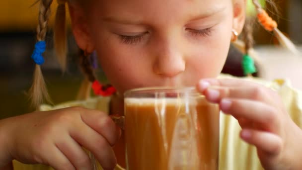 Little girl drinks a hot milk drink and burns hersel — Stock video