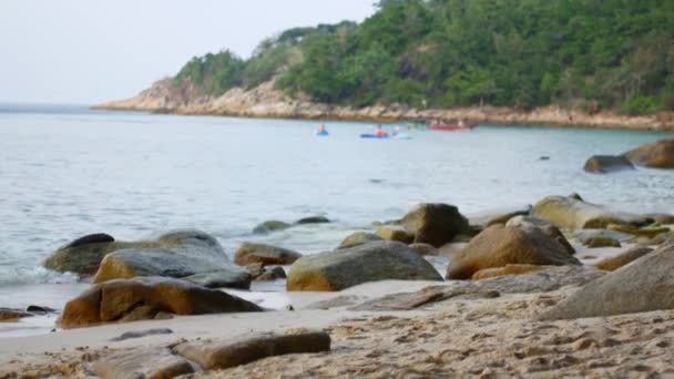 Θαλάσσιο τοπίο, πέτρες στην ακτή και κύματα, αγνώριστο αγόρι περπατά στο νερό — Αρχείο Βίντεο