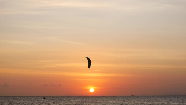 Zonsondergang op de oceaan, kitesurfers rijden op de zee — Stockvideo