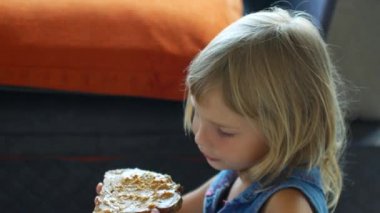 Child girl eats a peanut butter sandwich