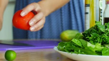 Salata için sebze dilimliyorum. Kadın, malzemeleri bıçakla parçalar.