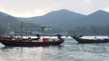 Sıcak bir körfezde dalgalar üzerinde sallanan balıkçı teknesi