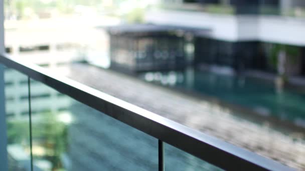 A little girl peeks over a glass railing. — Stockvideo