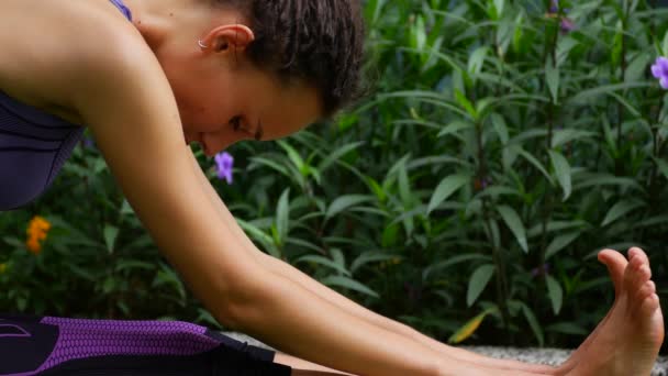 Young woman doing stretching on the grass — Stockvideo