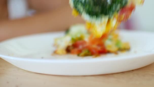 Un enfant cueille un œuf frit avec des légumes à la fourchette. Gros plan — Video