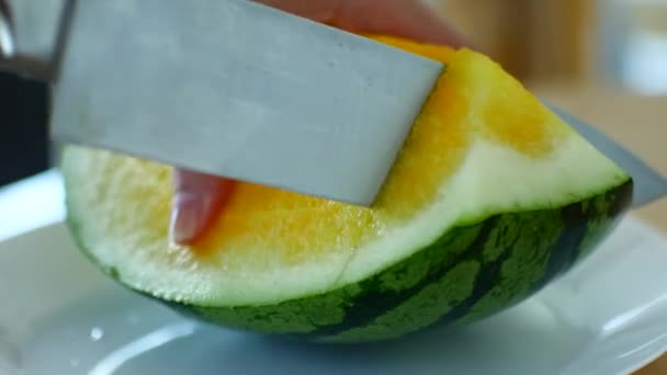 Woman cuts a yellow watermelon with a large knife. — Αρχείο Βίντεο