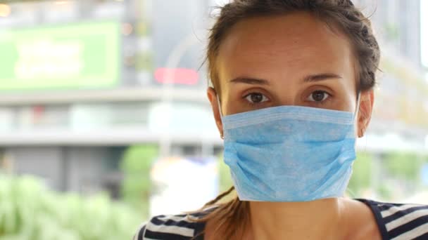 Vrouw zet een masker op ter bescherming tegen coronavirus 2019-ncov — Stockvideo