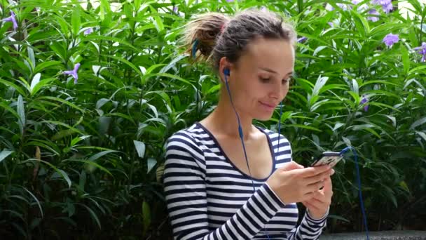 A young woman listens to music and communicates with friends on the Internet. — Αρχείο Βίντεο