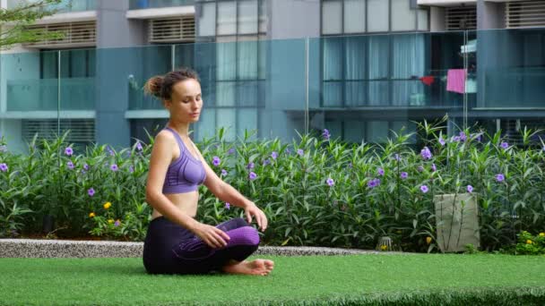 Young woman doing stretching on the grass — ストック動画