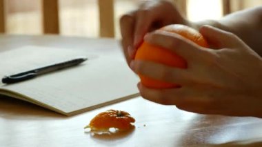 Kız elinde bir portakal tutuyor. Öğle yemeği molası.