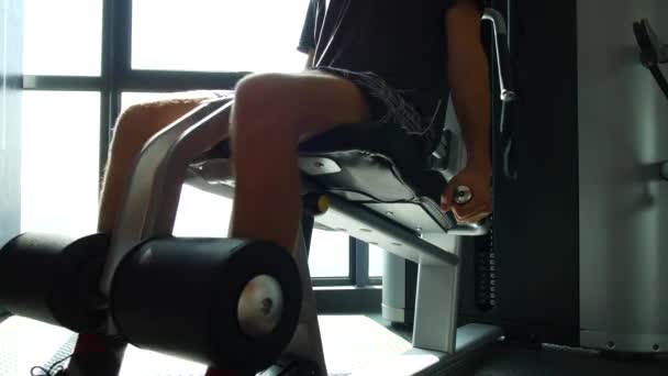 Mann trainiert Beine am Simulator im Fitnessstudio — Stockvideo