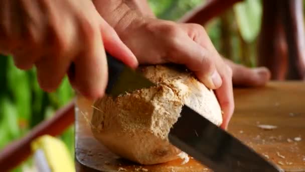 Um homem abre um coco fresco. close-up — Vídeo de Stock