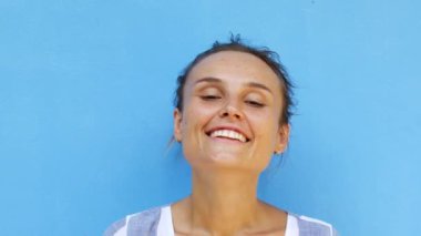 Genç bir kadın kameraya gülüyor.