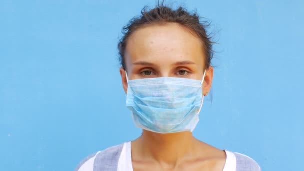 Een jonge vrouw doet haar gezichtsmasker af en lacht. Gemaskerde bloemen als metafoor voor herstel — Stockvideo