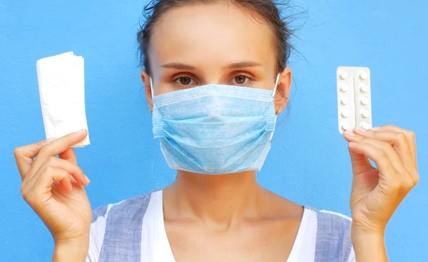 Woman in medical mask on a blue background. Concept for COVID-19, medical articles and news