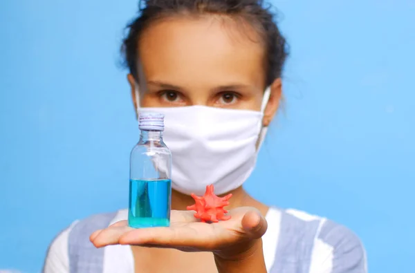 一个戴着口罩 手里拿着清洁剂和验尸官模型的女孩的画像 — 图库照片